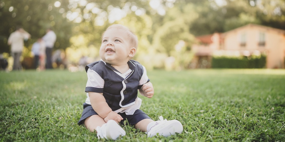 felicità di un bambino sul prato durante la festa del battesimo Bientina fotografo